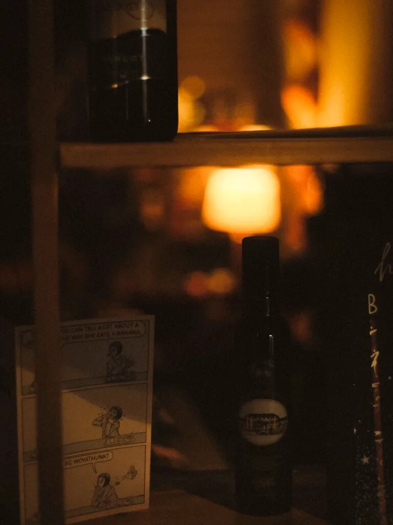 Figure in doorway lit by warm Emsworth shop lights