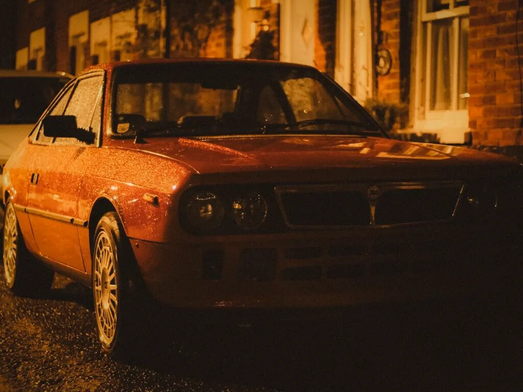 Silhouette of person walking on rain-soaked Emsworth street at night