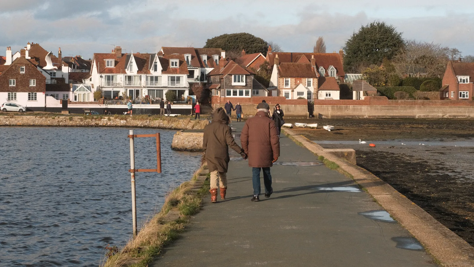 Couple walking along the causeway at Emsworth Harbour