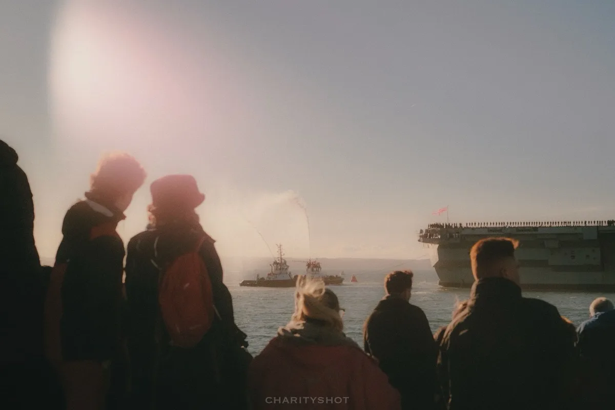 HMS Prince of Wales in Portsmouth with spectators watching
